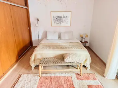 a bedroom with a large bed with a bench at Cozy apartment Marrakech hivernage with nice terrace in Marrakech