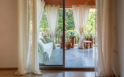 a living room with white curtains and a sliding glass door at Cozy apartment Marrakech hivernage with nice terrace in Marrakech