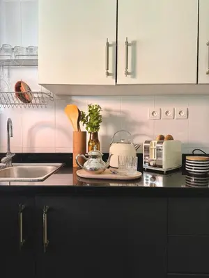 a kitchen with white cabinets and a black counter top at Cozy apartment Marrakech hivernage with nice terrace in Marrakech