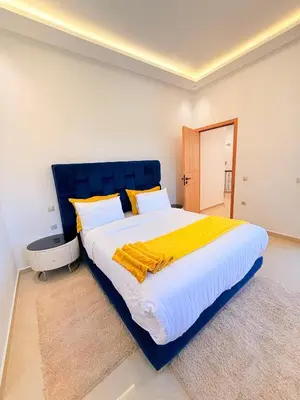 a large bed with a blue headboard in a bedroom at Villa privée in Marrakech