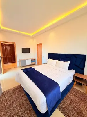 a bedroom with a large bed with a blue blanket at Villa privée in Marrakech