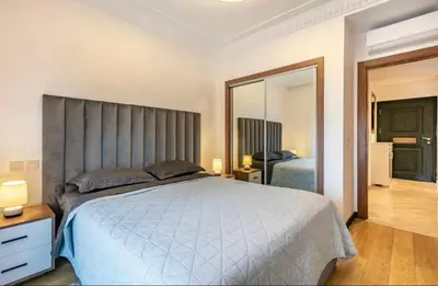 a bedroom with a large bed and a large mirror at Charme Central Appart Gueliz en Face La gare in Marrakech