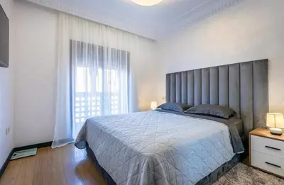 a bedroom with a large bed and a large window at Charme Central Appart Gueliz en Face La gare in Marrakech