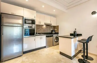 a kitchen with a stainless steel refrigerator and a counter at Charme Central Appart Gueliz en Face La gare in Marrakech