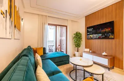 a living room with a blue couch and a table at Charme Central Appart Gueliz en Face La gare in Marrakech