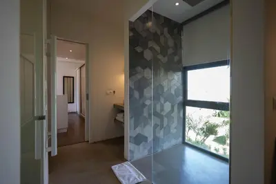 a bathroom with a glass wall with a window at Charmante villa de 4CH avec piscine privée - Proche du Beldi Country Club in Marrakech