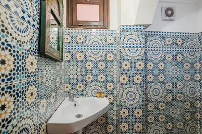 a bathroom with blue and white tiled walls and a sink at Riad - Jacuzzi & Breakfast , 5min walk Jemaa El Fnaa & Vue Rooftop Médina in Marrakech