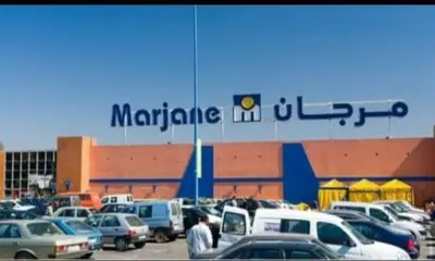 a parking lot full of cars in front of a large building at Marrake Appartement familiale au centre de in Marrakech