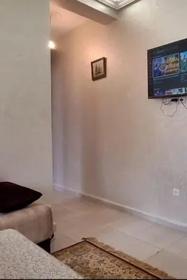 a living room with a couch and a tv on the wall at Marrake Appartement familiale au centre de in Marrakech