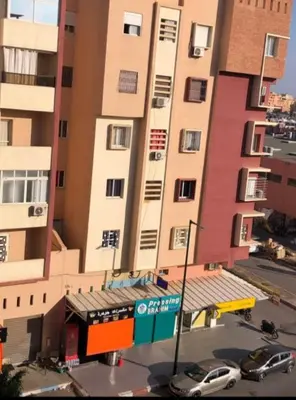 a tall building with cars parked in front of it at Marrake Appartement familiale au centre de in Marrakech