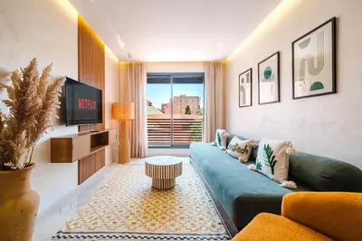 a living room with a couch and a tv at Modern and Cozy Apartment Center of Marrakech in Marrakech