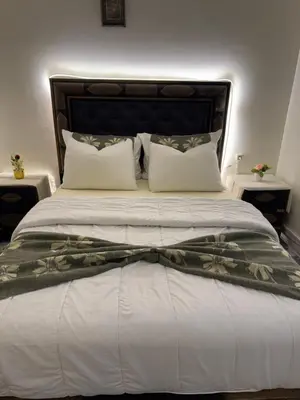 a bedroom with a large bed with white sheets and pillows at Only 5-minutes walk to airport, your perfect choice for an early or late flight in Oulad Akkou