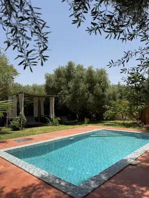 a swimming pool in a yard with trees at Villa Atlas Chill in Marrakech