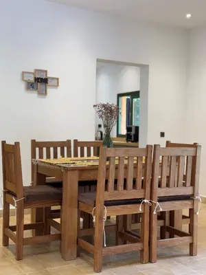 a dining room table and chairs with a cross on the wall at Villa Atlas Chill in Marrakech