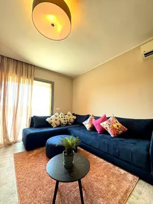 a living room with a blue couch and a table at Lovely 2 bedroom apartment in Marrakech