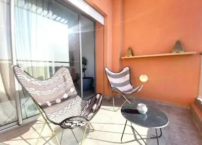 two chairs and a table in a room with a window at Lovely 2 bedroom apartment in Marrakech