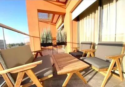 a patio with chairs and a table on a balcony at Lovely 2 bedroom apartment in Marrakech