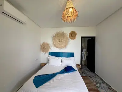 a bedroom with a bed with a chandelier above it at Villa familiale, piscine privée sans vis-à-vis in Marrakech