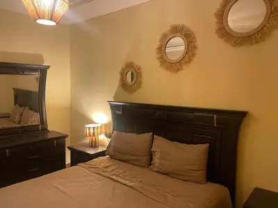 a bedroom with a bed and two mirrors on the wall at Duplex Village in Marrakech