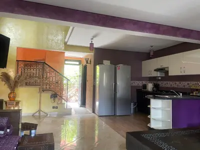 a kitchen with a stainless steel refrigerator and a staircase at Duplex Village in Marrakech