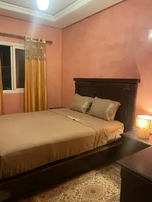 a bedroom with a bed and a window at Duplex Village in Marrakech