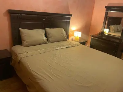 a bedroom with a large bed with white sheets and pillows at Duplex Village in Marrakech