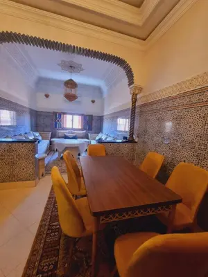 a dining room with a wooden table and yellow chairs at amazing home and amazing rooftop in Marrakech