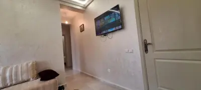 a living room with a couch and a tv on the wall at Appartement avec bel vue au centre de Marrakech in Marrakech