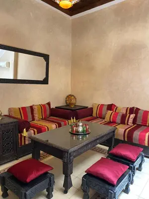 a living room with a couch and a table at Le Riad l'étoile beldi in Marrakech