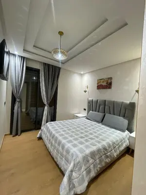 a bedroom with a large bed with a blue blanket at Apartment for rent in Marrakech