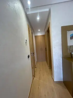 a hallway with white walls and wooden floors at Apartment for rent in Marrakech