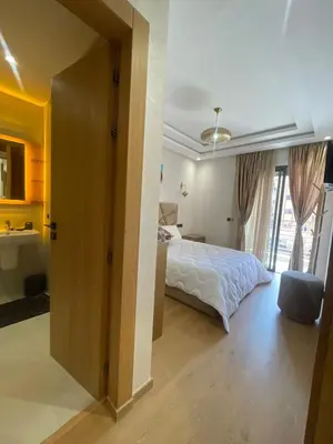 a bedroom with a bed and a bathroom with a window at Apartment for rent in Marrakech