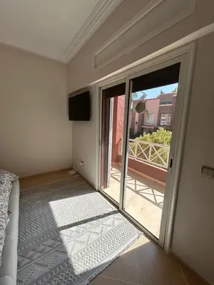 a bedroom with a sliding glass door to a balcony at Villa moderne avec jacuzzi & jardin - Marrakech in Marrakech