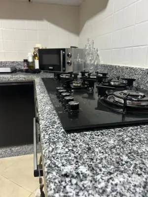a kitchen counter with a black stove top oven at Villa moderne avec jacuzzi & jardin - Marrakech in Marrakech