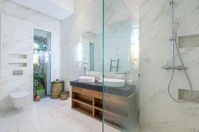 a bathroom with a sink and a glass shower at Villa Safiya, Piscine Chauffée & jeux in Marrakech