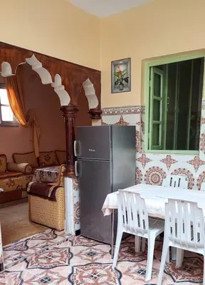 a kitchen with a refrigerator and a table and chairs at light stay in Marrakech
