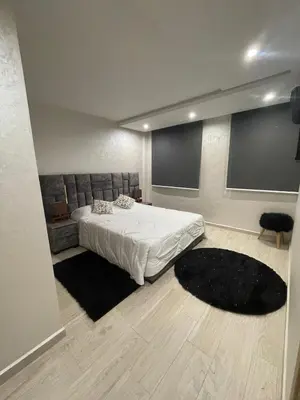 a bedroom with a white bed and a black rug at Apartment for rent ,Duplex in Marrakech