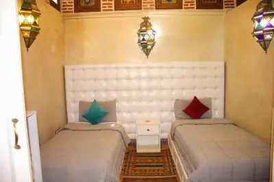 a bedroom with two beds and a table and lights at Riad-style villa with a private pool in Marrakech