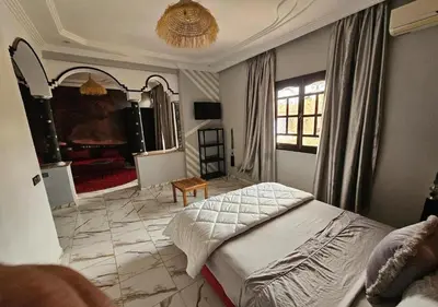 a bedroom with a bed and a living room at cozy villa in Marrakech