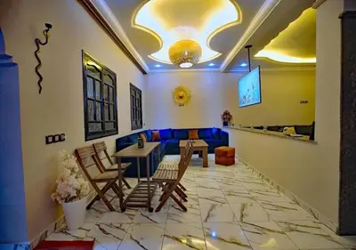 a living room with a table and chairs and a couch at cozy villa in Marrakech