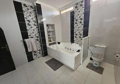a white bathroom with a tub and a toilet at cozy villa in Marrakech