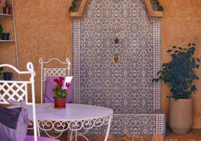 a table and chairs in front of a wall at cozy villa in Marrakech