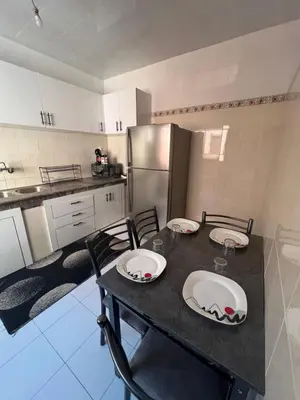 a kitchen with a table with chairs and a refrigerator at Marrakech gulize in Marrakech