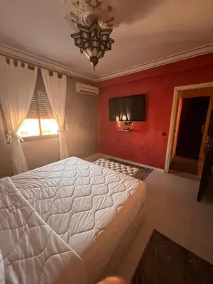 a bedroom with a white bed and a red wall at Marrakech gulize in Marrakech
