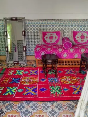 a room with a bed and a mirror and a rug at Riad Dar Medina Land in Marrakech