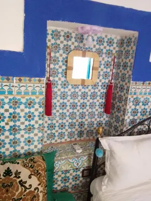 a room with a bed and a wall with a mirror at Riad Dar Medina Land in Marrakech