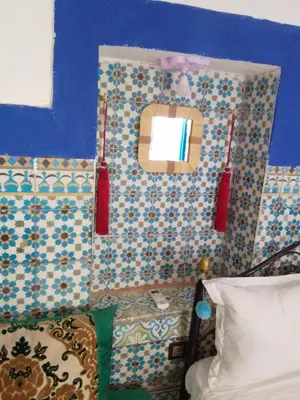 a bedroom with a blue wall and a mirror at Riad Dar Medina Land in Marrakech