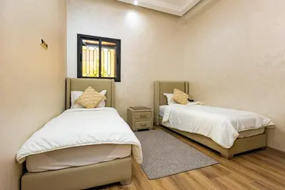 a bedroom with two beds and a window at Elegant and Modern Apartment, Calm Cosy and Central in Marrakech