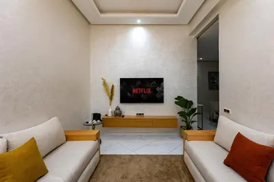 a living room with two white couches and a tv at Elegant and Modern Apartment, Calm Cosy and Central in Marrakech