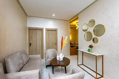 a living room with a couch and chairs and mirrors at Elegant and Modern Apartment, Calm Cosy and Central in Marrakech